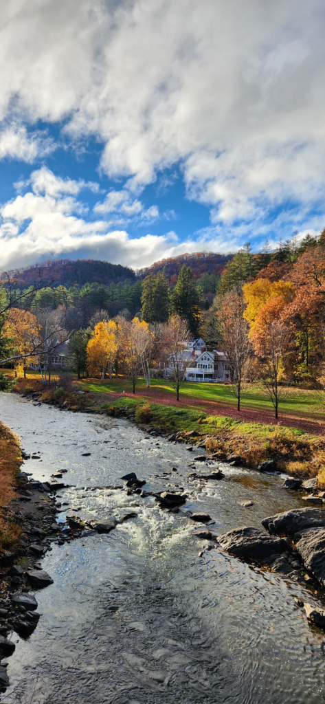 Fall foliage along a river in Woodstock, Vermont during a New England road trip